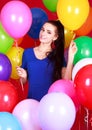 Portrait of a young attractive woman among many bright balloons