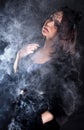 Portrait of a young attractive woman in a puff of smoke Royalty Free Stock Photo