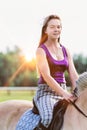 Portrait of young attractive woman riding horse in ranch Royalty Free Stock Photo