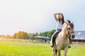 Portrait of young attractive woman riding horse in ranch Royalty Free Stock Photo