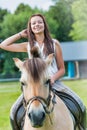 Portrait of young attractive woman riding horse in ranch Royalty Free Stock Photo