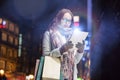 Portrait of young attractive woman smiling and using digital tablet while on night shopping Royalty Free Stock Photo