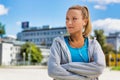 Portrait of young attractive woman standing with arms crossed while listening to music on her smartphone in park Royalty Free Stock Photo