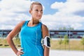 Portrait of young attractive woman standing while listening to music on her smartphone in park Royalty Free Stock Photo