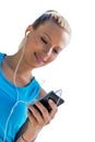 Portrait of young attractive woman standing while using and listening to music on her smartphone in park Royalty Free Stock Photo