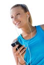 Portrait of young attractive woman standing while using and listening to music on her smartphone in park Royalty Free Stock Photo