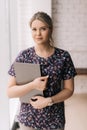 Portrait of young attractive woman wearing casual clothing holding folders while standing in office Royalty Free Stock Photo