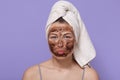 Portrait of young attractive woman with white towel on her head, posing isolated over lilac background with pouty lips, looks Royalty Free Stock Photo