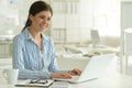 Portrait of young attractive woman working with laptop in office Royalty Free Stock Photo