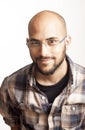 Portrait of a young bald man with a beard and glasses