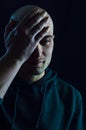 Portrait of a young bald man who partially covers his face with his hand on his forehead and looks sad Royalty Free Stock Photo