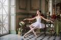 Portrait of a young ballerina on pointe shoes in a black swimsuit, tutu and pointe shoes in a luxurious interior. Royalty Free Stock Photo