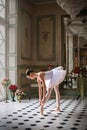 Portrait of a young ballerina on pointe shoes in a black swimsuit, tutu and pointe shoes in a luxurious interior. Royalty Free Stock Photo