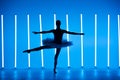 Portrait of a young ballerina on pointe shoes in a white tutu against background of bright blue neon lights. A young Royalty Free Stock Photo