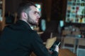 Portrait of young bearded Caucasian businessman dressed smart casual using phone inside modern coworking space Royalty Free Stock Photo