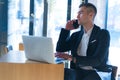 Portrait of young bearded Caucasian businessman dressed smart casual using phone inside modern coworking space Royalty Free Stock Photo