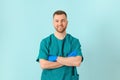 Portrait young bearded doctor with stethoscope over neck in medical coat standing against isolated blue background Royalty Free Stock Photo