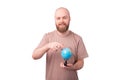 Portrait of young bearded man pointing at globe, travel concept Royalty Free Stock Photo