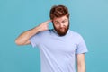 Man in T-shirt showing stupid gesture with finger near head, out of mind, accusing crazy dumb plan. Royalty Free Stock Photo