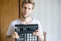 Portrait of young bearded man sound producer holding midi controller and headphones f