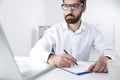 Portrait of a young bearded man taking notes Royalty Free Stock Photo