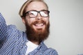 Portrait of young bearded man taking selfie and holding camera Royalty Free Stock Photo