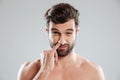 Portrait of a young bearded naked man picking his nose Royalty Free Stock Photo