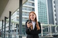 Portrait of A young Beautiful Asian businesswoman wearing a suit standing in a big city using a smartphone. Young Asian Royalty Free Stock Photo