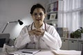 Portrait of young beautiful Asian female doctor looking at camera in medical office, having online consultation with patient. Youn Royalty Free Stock Photo