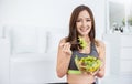 Portrait of young beautiful asian girl in sportswear holding a glass bowl of salad fork in her hands. Royalty Free Stock Photo