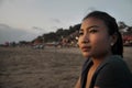 Beautiful Asian lonely woman looking to infinity lost in her thoughts sad and thoughtful sitting on sand beach Royalty Free Stock Photo