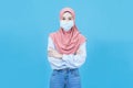 Portrait of young beautiful asian muslim woman  in traditional dress wearing medical face mask folded arms influenza viral disease Royalty Free Stock Photo