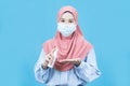 Portrait of young beautiful asian muslim woman in traditional dress wearing medical face mask Royalty Free Stock Photo