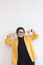 portrait of young beautiful Asian Muslim woman, wearing glasses and yellow blazer with happy smiling face expression Royalty Free Stock Photo