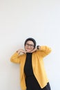 portrait of young beautiful Asian Muslim woman, wearing glasses and yellow blazer with happy smiling face expression Royalty Free Stock Photo