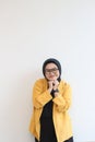 portrait of young beautiful Asian Muslim woman, wearing glasses and yellow blazer with happy smiling face expression Royalty Free Stock Photo