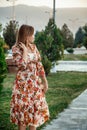 Portrait of a young beautiful Asian skinny slender woman in a floral print dress standing outside during sunset Royalty Free Stock Photo