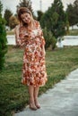 Portrait of a young beautiful Asian skinny slender woman in a floral print dress standing outside during sunset Royalty Free Stock Photo