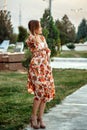 Portrait of a young beautiful Asian skinny slender woman in a floral print dress standing outside during sunset Royalty Free Stock Photo