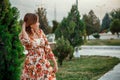 Portrait of a young beautiful Asian skinny slender woman in a floral print dress standing outside during sunset Royalty Free Stock Photo