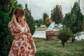 Portrait of a young beautiful Asian skinny slender woman in a floral print dress standing outside during sunset Royalty Free Stock Photo