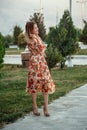 Portrait of a young beautiful Asian skinny slender woman in a floral print dress standing outside during sunset Royalty Free Stock Photo