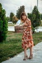 Portrait of a young beautiful Asian skinny slender woman in a floral print dress standing outside during sunset Royalty Free Stock Photo