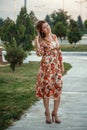 Portrait of a young beautiful Asian skinny slender woman in a floral print dress standing outside during sunset Royalty Free Stock Photo