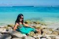 Portrait of young beautiful asian smiling girl laying on the rocks at the beach Royalty Free Stock Photo