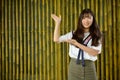 Happy young beautiful Asian teenage girl against bamboo fence Royalty Free Stock Photo