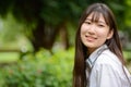 Happy young beautiful Asian teenage girl thinking at the park Royalty Free Stock Photo