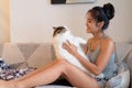Happy young beautiful Asian woman playing with Persian cat on the couch Royalty Free Stock Photo