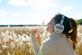 Profile view of young happy beautiful Asian woman looking at scenic view of autumn bulrush field