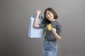 Portrait of young beautiful asian woman holding credit card and colorful shopping bag isolated over gray background studio Royalty Free Stock Photo